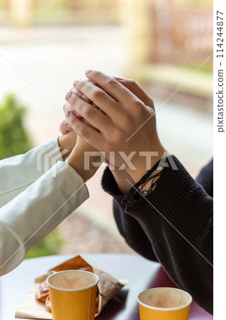 Couple enjoying a coffee holding hands. Couple enjoying a coffee holding hands. 114244877
