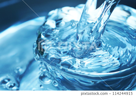 Water falling vigorously into a glass 114244915