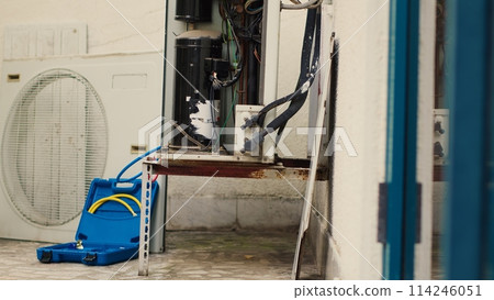 Tilt up shot of air conditioner side panel opened before scheduled maintenance appointment check. Close up of intricate wiring and HVAC system refrigerant tank needing to be repaired 114246051