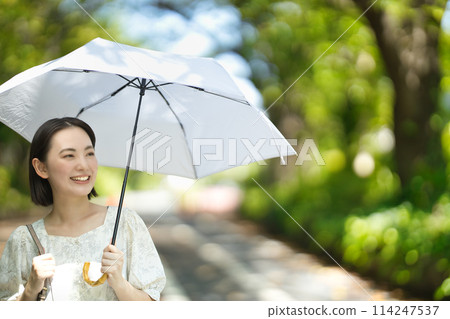 拿著遮陽傘的一個少婦 拿著遮陽傘的一個少婦 114247537