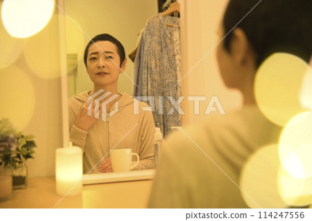 A middle-aged woman who does her nighttime skin care routine while worrying about rough skin A middle-aged woman who does her nighttime skin care routine while worrying about rough skin 114247556