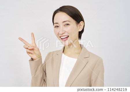 Middle-aged business woman making a peace sign on white background 114248219