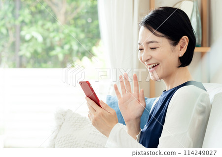 A middle-aged woman operating a smartphone 114249027