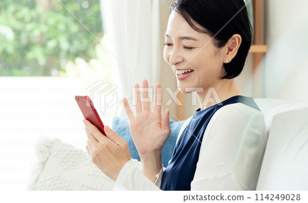 A middle-aged woman operating a smartphone A middle-aged woman operating a smartphone 114249028