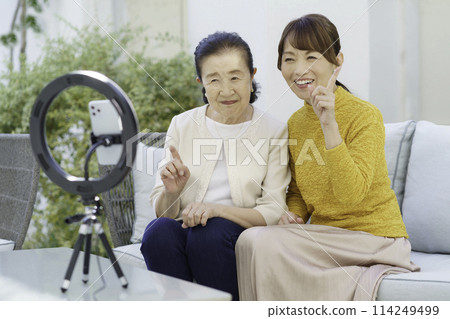 Senior and middle-aged women streaming videos 114249499