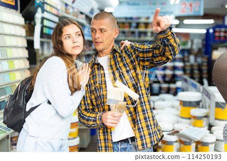 Woman and man points his hand at something in hardware store 114250193