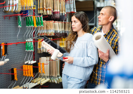 Happy married couple are choosing different tools at hardware store Happy married couple are choosing different tools at hardware store 114250321