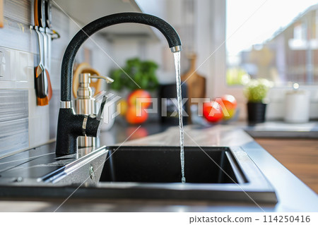 Bright modern kitchen interior with an open faucet 114250416