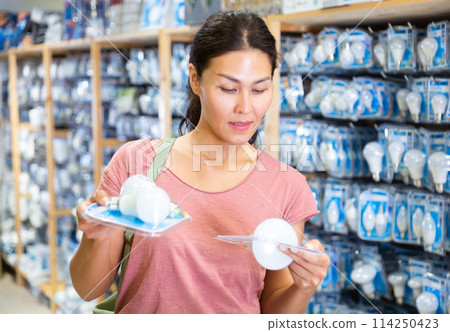 Woman choosing bulbs in store Woman choosing bulbs in store 114250423
