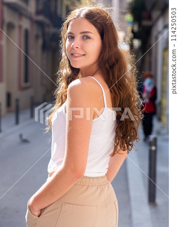 Cheerful attractive female walking on street outdoor Cheerful attractive female walking on street outdoor 114250503