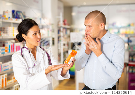 Man asks to help pharmacist choose medicine for toothache 114250614