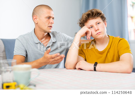 Son feeling sad and father talking to him 114250648