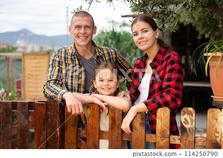 Family with daughter resting after harvesting in garden 114250790