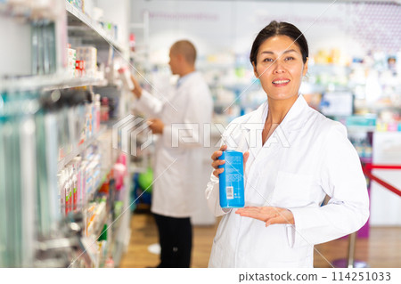 Female pharmacist with sanitizer in drugstore 114251033