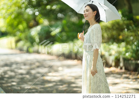 拿著遮陽傘的一個少婦 拿著遮陽傘的一個少婦 114252271