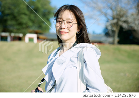 A woman walking with a camera 114253676