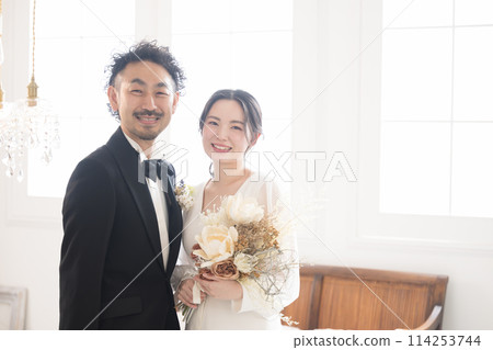 Pregnant bride and groom at a wedding, age difference couple, looking at the camera for pre-wedding photos, bridal, wedding, etc. 114253744