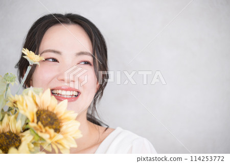 可愛的女人拿著一束向日葵，用於新娘、美容、預拍攝等的可愛圖像的特寫。 114253772