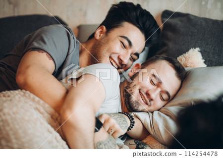 Positive delighted non-traditional couple sleeping together Positive delighted non-traditional couple sleeping together 114254478