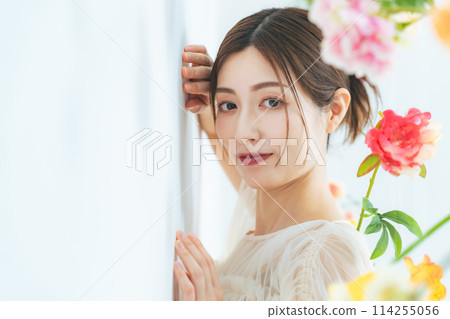 Portrait of a middle-aged woman surrounded by flowers Portrait of a middle-aged woman surrounded by flowers 114255056