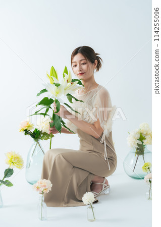 Portrait of a middle-aged woman surrounded by flowers 114255096