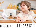 A boy sits at kitchen of rustic style with Easter decorations 114255811