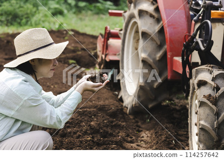 A woman checking the soil in a field A woman checking the soil in a field 114257642