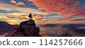 Adventure Woman Hiker Standing on a peak. Mountain Landscape in Background. Dramatic Sunset. 114257666