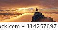 Adventure Woman Hiker Standing on a peak. Mountain Landscape in Background. Dramatic Sunset. 114257697