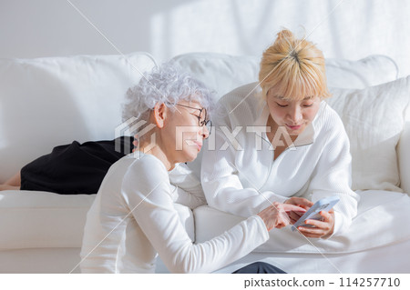 Family: Mother and daughter looking at smartphone 114257710