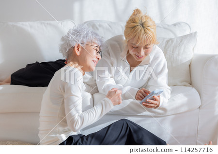 Family: Mother and daughter looking at smartphone 114257716