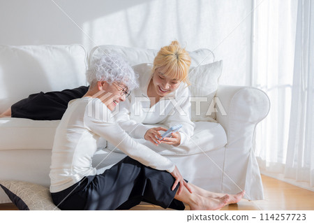 家庭：看著智慧型手機的母親和女兒 114257723