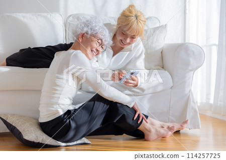 家庭：看著智慧型手機的母親和女兒 114257725