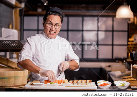 gorgeous attractive man with raised eyebrows posing to the camera in the kitchen gorgeous attractive man with raised eyebrows posing to the camera in the kitchen 114258181