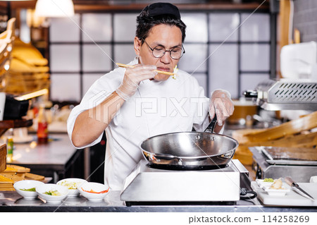 unhappy frustrated chef smelling overcooked dish 114258269