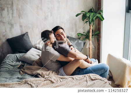 Two sexy caucasian gay guys hugging and having fun in bed indoors Two sexy caucasian gay guys hugging and having fun in bed indoors 114258327