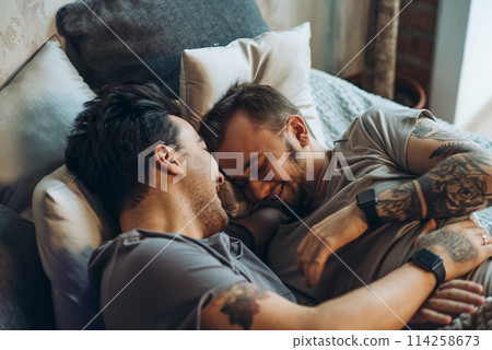 A homosexual couple on bed in studio with loft interior A homosexual couple on bed in studio with loft interior 114258673