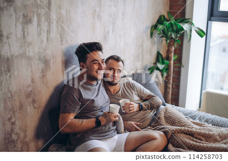 Perfect morning begins with lover and coffee in bed. Two guys resting in bed. Perfect morning begins with lover and coffee in bed. Two guys resting in bed. 114258703