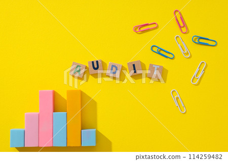 Diagram, clips and wooden cubes with letters on yellow background, top view 114259482