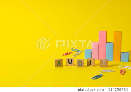 Diagram, clips and wooden cubes with letters on yellow background, space for text 114259484