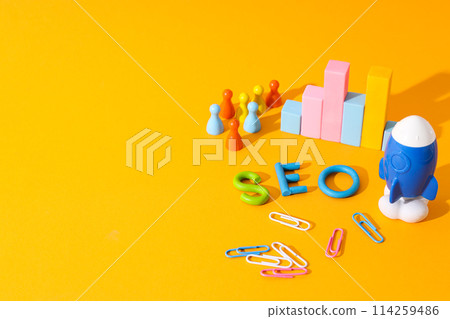 Diagram, clips, toy rocket and letters on yellow background, space for text Diagram, clips, toy rocket and letters on yellow background, space for text 114259486