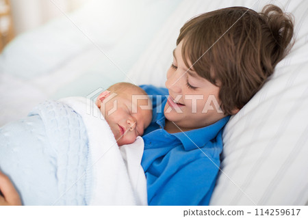 Siblings meet newborn baby in hospital 114259617