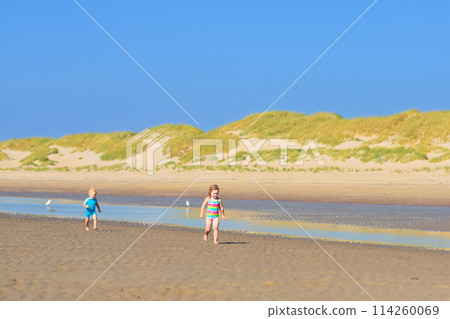 Kids playing on beach. Children play at sea. Kids playing on beach. Children play at sea. 114260069