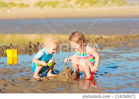 Kids playing on beach. Children play at sea. Kids playing on beach. Children play at sea. 114260071