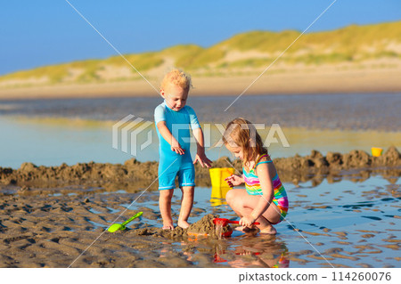 Kids playing on beach. Children play at sea. Kids playing on beach. Children play at sea. 114260076