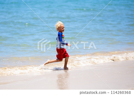 Kids playing on beach. Children play at sea. 114260368