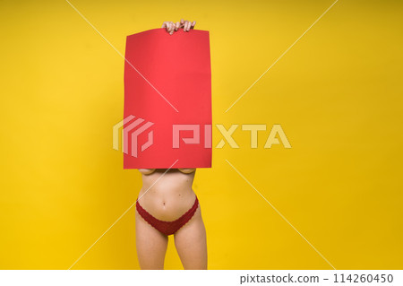 Blonde model, Young woman holding a cardboard cloud red sheet of papaer, a place for an inscription Blonde model, Young woman holding a cardboard cloud red sheet of papaer, a place for an inscription 114260450