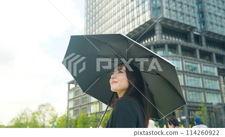 Woman holding a parasol in the city 114260922