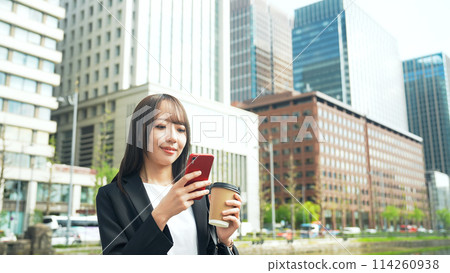 Female business person using a smartphone in the city Female business person using a smartphone in the city 114260938