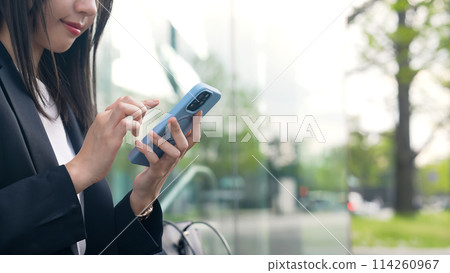 在街角使用智慧型手機的女商人 114260967